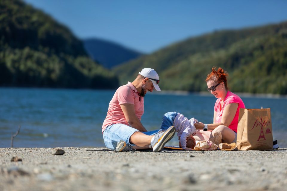 Family relaxing by a lake on a sunny day
